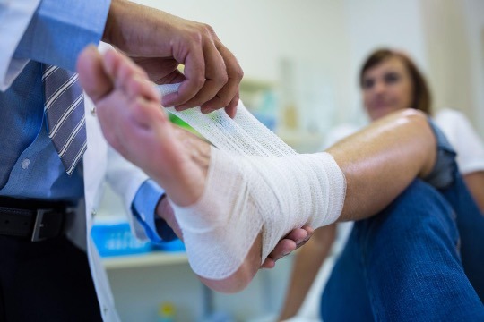 doctor wrapping foot injury