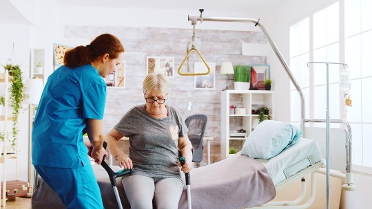 nurse helping elder woman